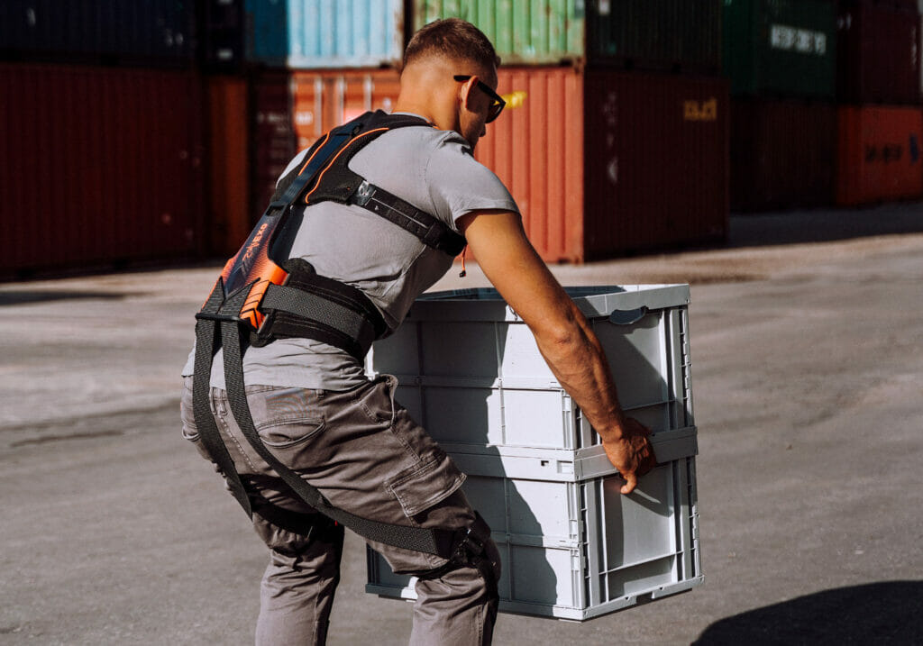 Worker wearing Hunic Exoskeleton lifting boxes